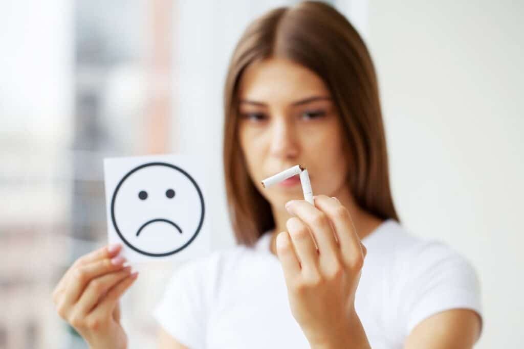 Femme avec une cigarette à la main, symbolisant des années de tabagisme avant un sevrage accompagné par hypnose