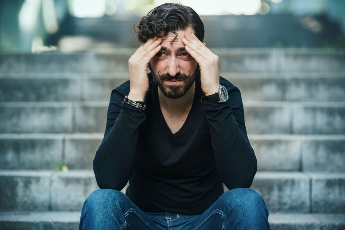 Hypnose et dépression : homme assis tête entre les mains, détresse émotionnelle