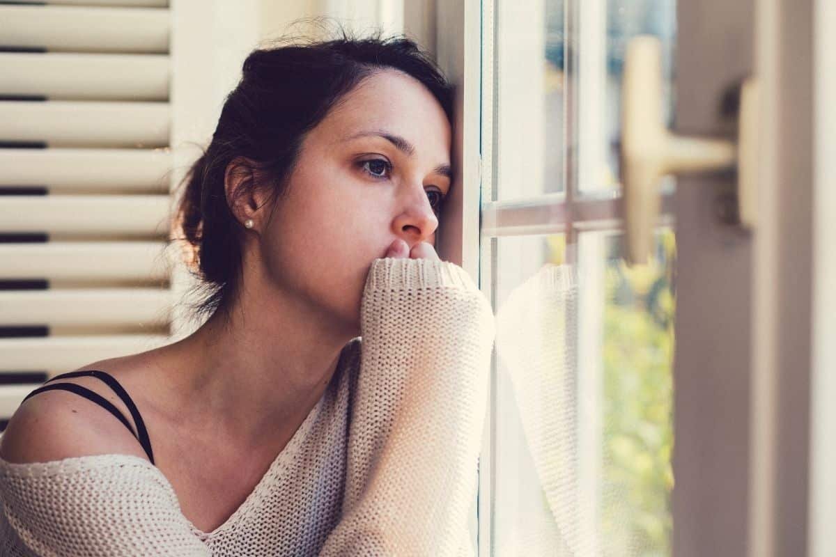 Hypnose et dépression : femme pensive à la fenêtre, mélancolie d'un état dépressif